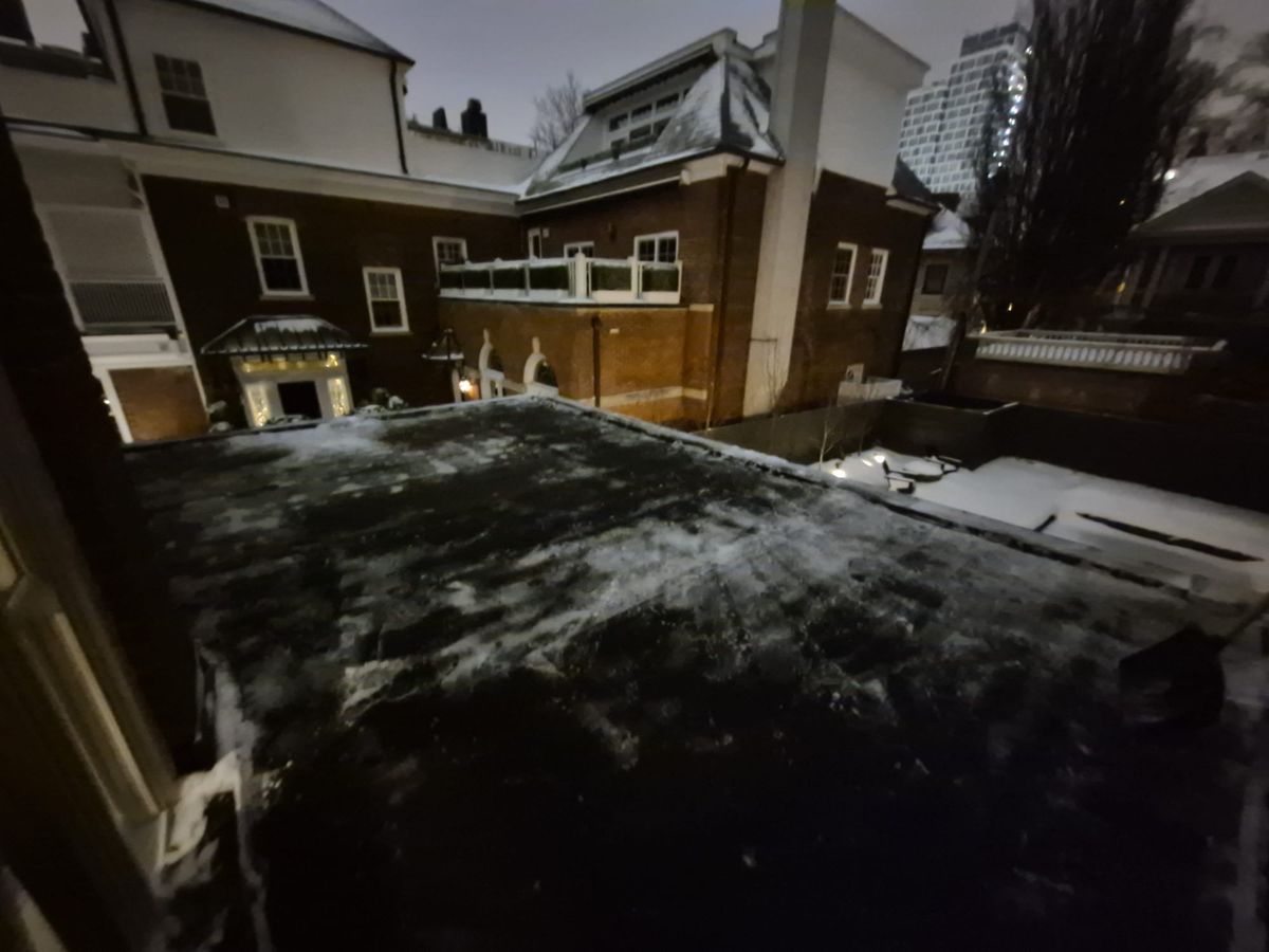 Flat roof behind a row of Toronto homes with the heavy snow shovelled off