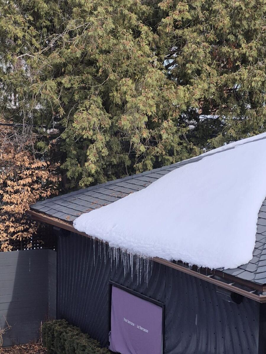Long icicles along a snow-covered gutter